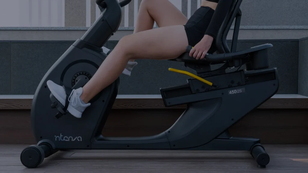 A person cycling on a recumbent bike indoors in a modern, well-lit home setting.